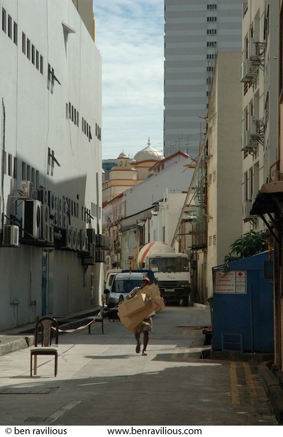 Man carrying cardboard boxes in a side street: Mackenzie Road, Singapore, 15 December 2005